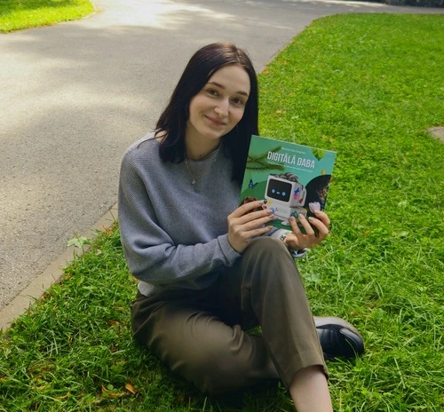 Bilde ar meiteni, kas tur rokās grāmatu "digitālā daba"